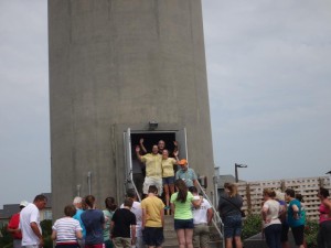 Julia and Chris are greeted with applause as they emerge from the lighthouse after their top climb and successful engagement!